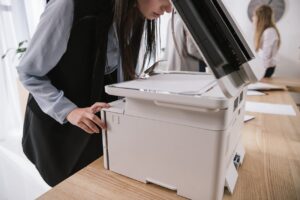 Kobieta obsługuje drukarkę